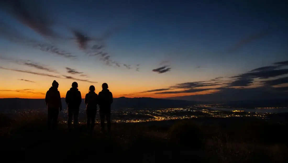 Grupo de personas contemplando el horizonte desde un mirador al anochecer